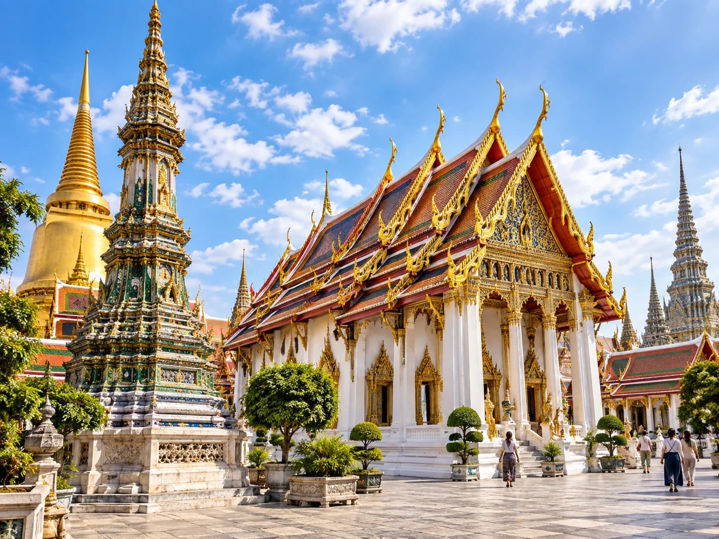 Thai temple courtyard with gold and red layered roofs